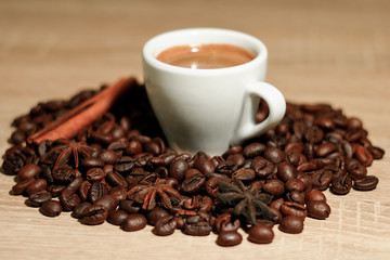 A cup of coffee with heart pattern in a white cup on wooden background