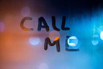 the words call me handwritten by finger on night foggy wet window glass