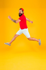 Fototapeta na wymiar Always in motion. Enjoying active lifestyle. Happy guy jumping. Active bearded man in motion yellow background. Active and energetic hipster. Energy charge. Healthy guy feeling good. Inspired concept