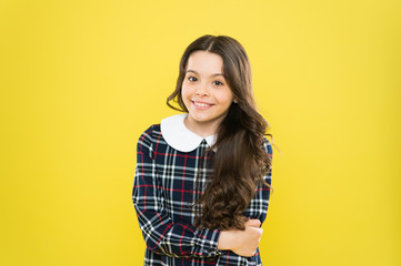 glamour girl model. real beauty. Small scottish girl. stylish school uniform for kids. be fashionable everyday. happy childhood concept. little fashion model yellow background. her hair is perfect