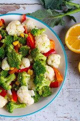 Bowl of fresh vegetable salad on wooden background