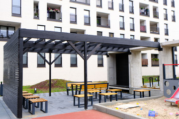 Benches, tables and playground. Place for a rest in a cozy courtyard of modern residential district.