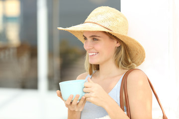 Happy tourist drinking coffee at hotel terrace