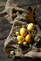 Easter eggs on wooden background. Gold handmade easter eggs in a basket.
