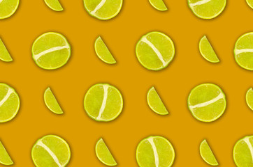 Colorato modello di frutta di fette fresche di lime su sfondo arancione.. Vista dall'alto.