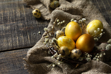 Easter eggs on wooden background. Gold handmade easter eggs in a basket. Copy space.
