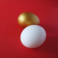 Golden and white eggs lie on a red background. Happy easter concept.