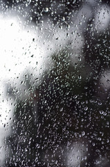 Rain drops on window glasses surface with bokeh background.