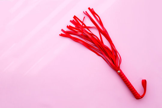 Leather Red Whip On A Pink Background. Sex Toy. Flat Lay.