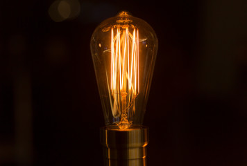 Electric lamp. A light bulb shines in the dark.