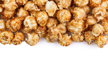 Heap of delicious caramel popcorn, isolated on white background. Scattered popcorn texture background . Selective focus.