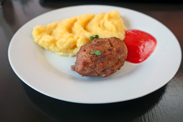 cutlet with mashed potatoes and tomato ketchup on a plate
