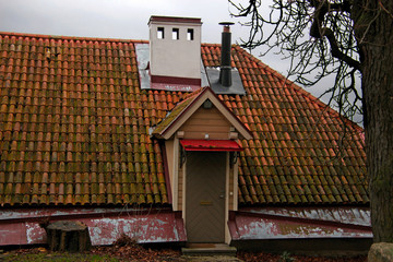 tiled roof door under a white chimney leading to the attic