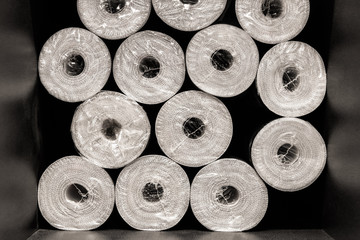 Packed rolls of white wallpaper close-up in a hardware store