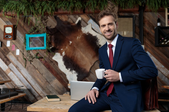 happy businessman drinking coffee and smiling
