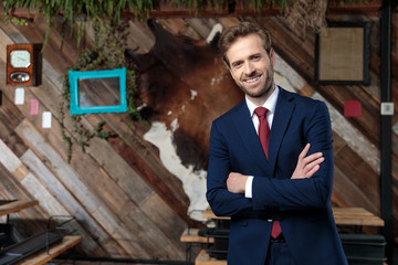 happy young businessman crossing arms and smiling