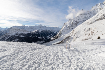 Wide angle view from the summit of Mont Blanc, with peaks emerging from a snow-covered glacier