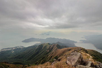 Fototapeta na wymiar Lantau island is not far from Hong Kong, but the path to Lantau peak is very difficult, especially in winter with wind and fog. The reward for climbing is stunning views from the top of the mountain.