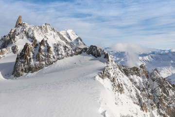 Wide angle view from the summit of Mont Blanc, with peaks emerging from a snow-covered glacier