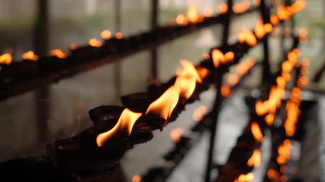Closeup 4k video of burning oil lamps in the buddhist temple on Sri Lanka