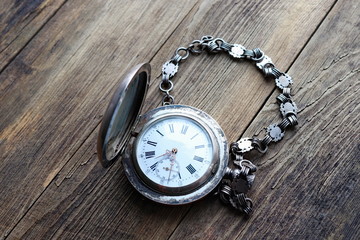 vintage silver pocket watch, old wooden background