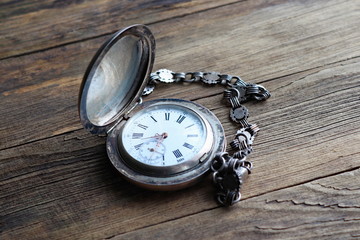 vintage silver pocket watch, old wooden background