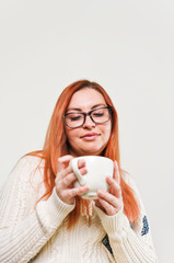 A woman with freckles drinking coffee or tea