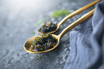 Black Caviar in a spoon on dark background. High quality real natural sturgeon black caviar...