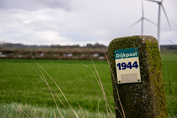 Dike pile sign in front of landscape