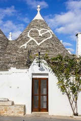Fototapeta na wymiar Heart and arrow sign on a Trulli house roof in Alberobello, Puglia, Italy