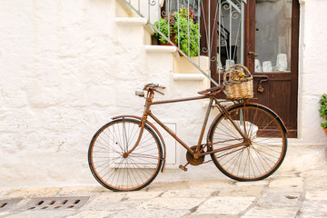 Fototapeta na wymiar An old, rusty bike used as decoration with flower basket in front of a house