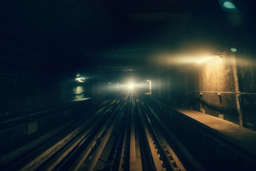 Fototapeta na wymiar Dubai metro tunnel in blurred motion, view from first wagon, subway tracks.
