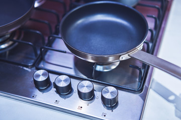 Close-up of griddle on a gas stove with handles for adjusting the heating force. Selective focus....