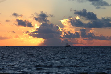 Golden sunrise behind clouds over a deep blue ocean in the Atlantic Ocean