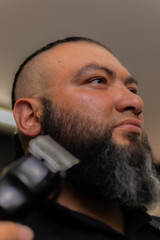 Obraz premium Latin American barber working the style with a long beard in the city of Bogotá.