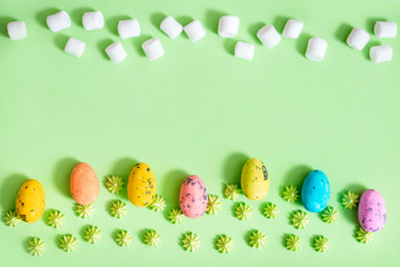 Easter holiday concept.Colorful flowers in the meadow, sweet green candy. easter card.Colorful Easter eggs line up green grass background.Horizontal pattern, border