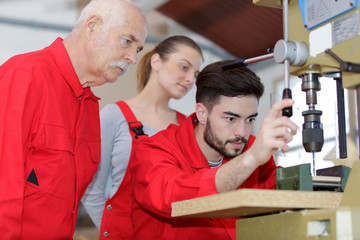 engineer training female apprentice on milling machine