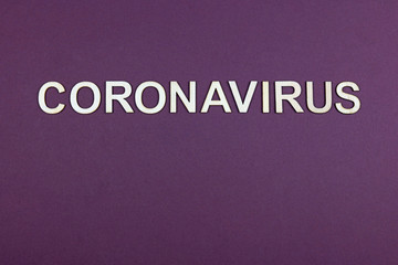 Wooden letters spelling coronavirus on a purple background
