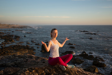 Fototapeta na wymiar Yoga woman sitting in Lotus position on the sea beach..