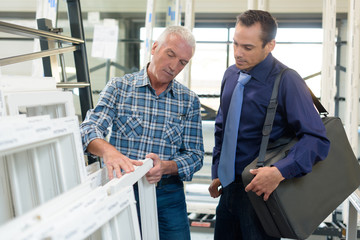 portrait of smiling satisfied worker at pvc windows factory