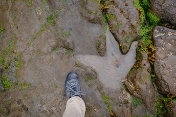 Human foot compared to a dinosaur footprint on the An Corran Beach, near Skye, Portree, Scotland UK