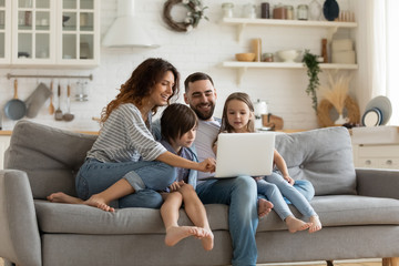 Happy family with kids sit on couch using laptop - Powered by Adobe