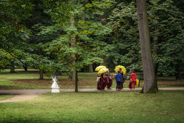 Young women with umbrellas talking in the park