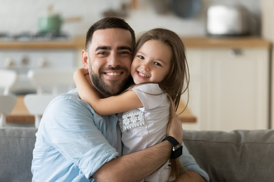 Portrait of happy young dad and daughter hugging