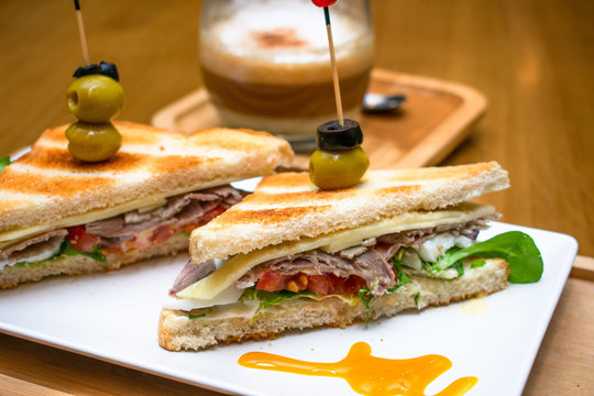 Sandwich gourmet con caf&eacute; de fondo