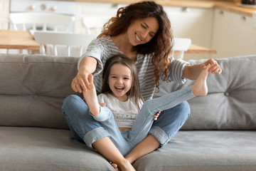 Fototapeta premium Happy mother playing with small girl at home
