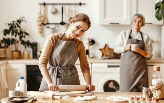 happy family grandmother  old mother mother-in-law and daughter-in-law daughter cook in kitchen, knead dough, bake cookies.