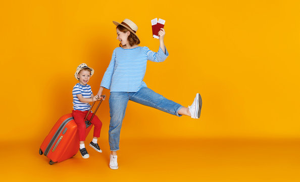 happy journey! family of travelers mother and child  with suitcases tickets and passports on yellow background.