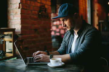young man  working in cafe and drink black coffee