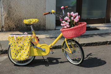 gelbes Kinderrad mit Blumenkorb